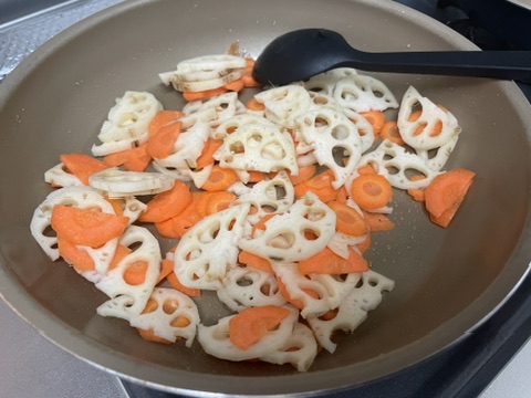 れんこんとにんじんをごま油で炒めているところ